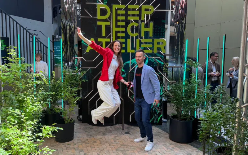 Attendees celebrating in front of the Deep Tech Atelier 2026 wall