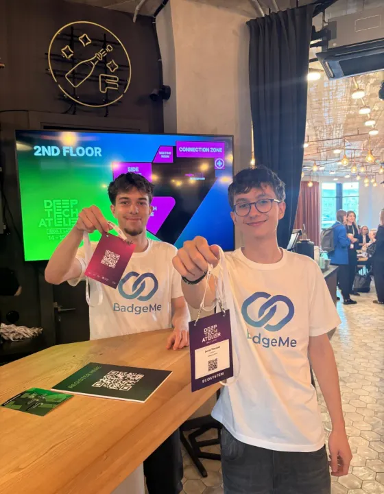 Two attendees showing their printed BadgeMe badges