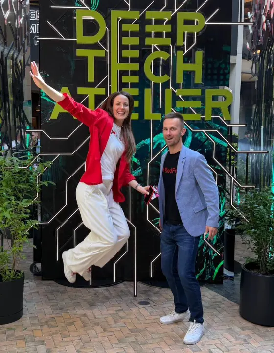 Attendees jumping in front of the Deep Tech Atelier wall